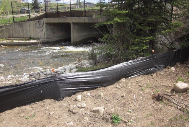 A storm water construction project creates a barrier along the river to ease flooding